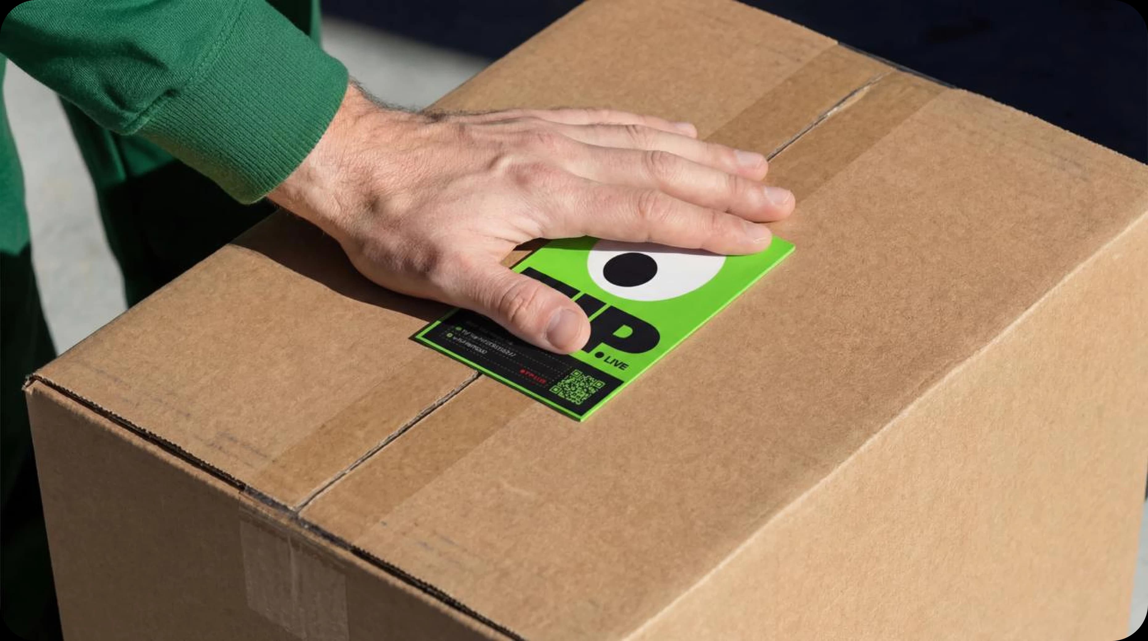 Hand placing TIP tracking label on a cargo box